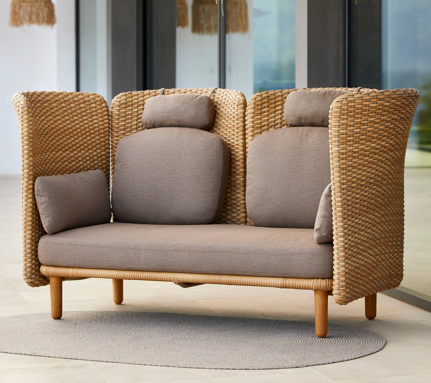 Stilig to-seters sofa med vevd tekstur, som har komfortable puter og en base av naturlig tre, ideell for avslapning.